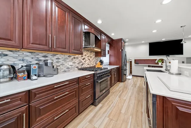 a kitchen with stainless steel appliances granite countertop a sink dishwasher stove and oven with wooden floor