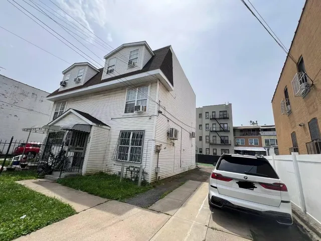a car parked in front of a white house