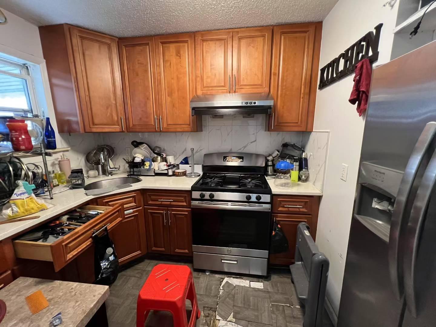 34-18 103rd Street Queens, NY 11368 - Photo 9 of 12 a kitchen with stainless steel appliances granite countertop a sink stove and cabinets