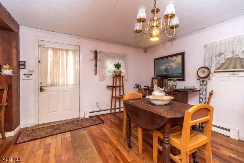 400 Mechlin Corner Road Pittstown, NJ 08867 - Photo 8 of 29 a view of a dining room with furniture a chandelier and wooden floor