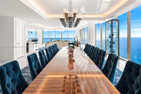 a view of a dining room with furniture a chandelier and wooden floor