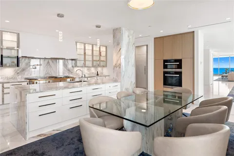 a kitchen with stainless steel appliances kitchen island granite countertop a table and chairs