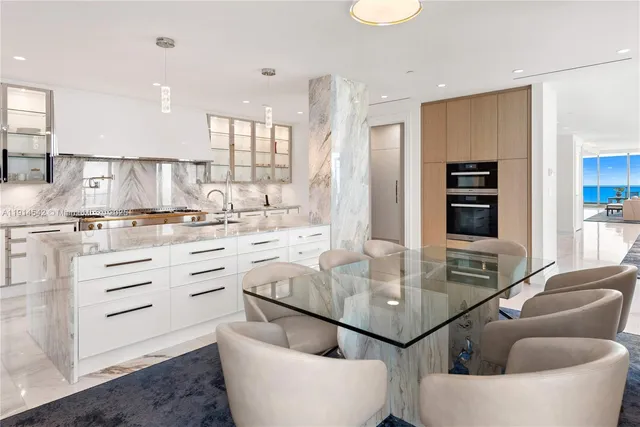a kitchen with stainless steel appliances kitchen island granite countertop a table and chairs