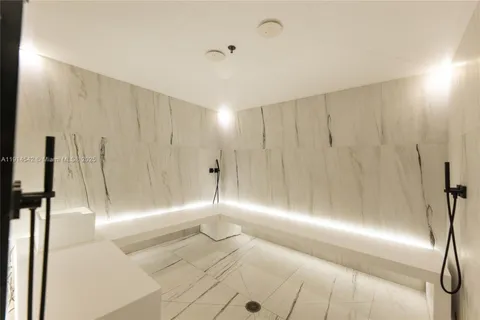 a hallway with a large mirror and fan