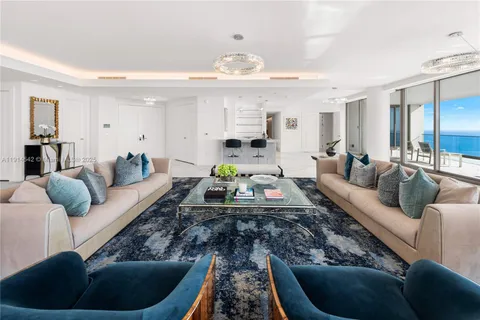 a living room with furniture and a chandelier