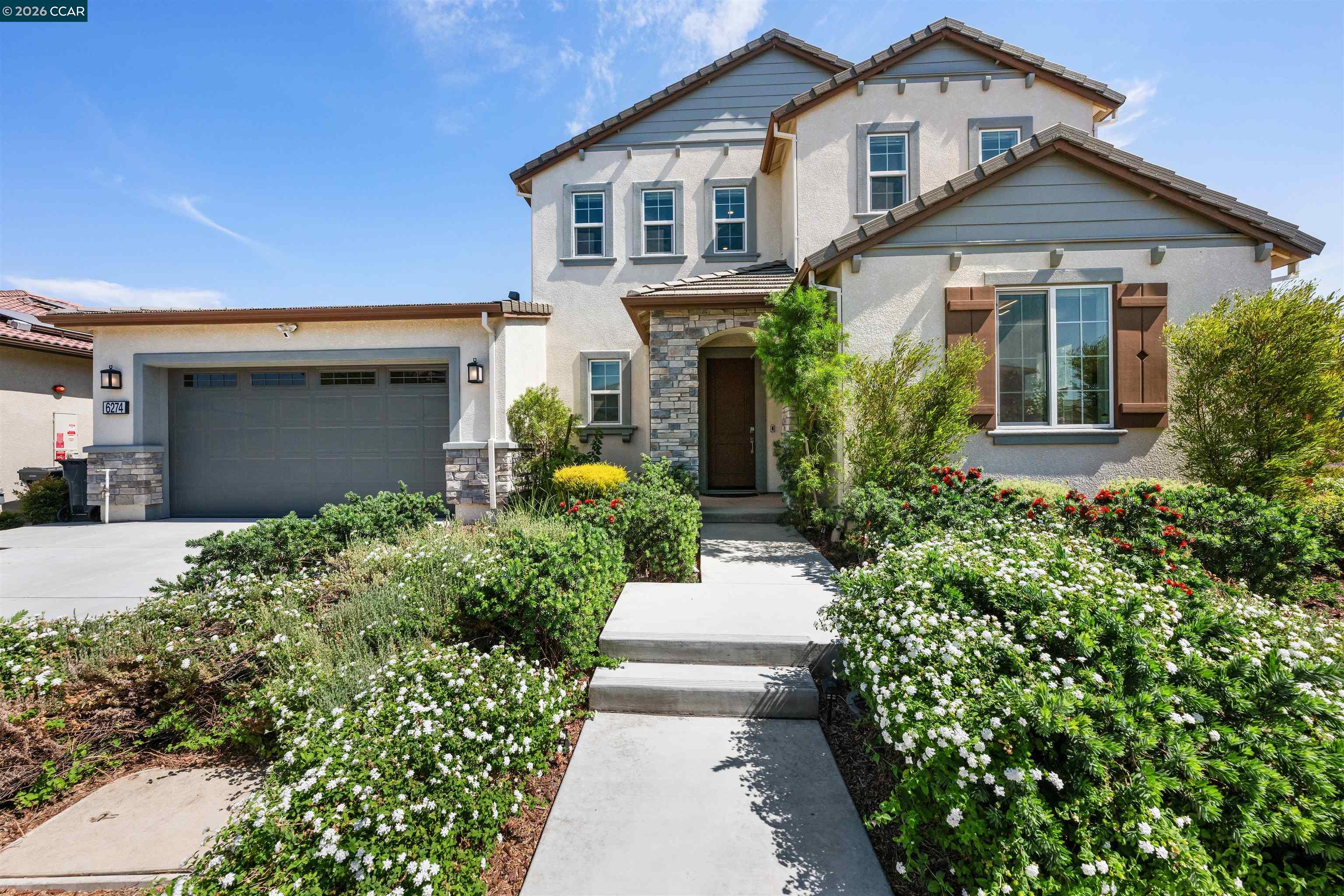 6274 Carousel Avenue Tracy, CA 95377 - Photo 1 of 46 a front view of a house with a yard and potted plants