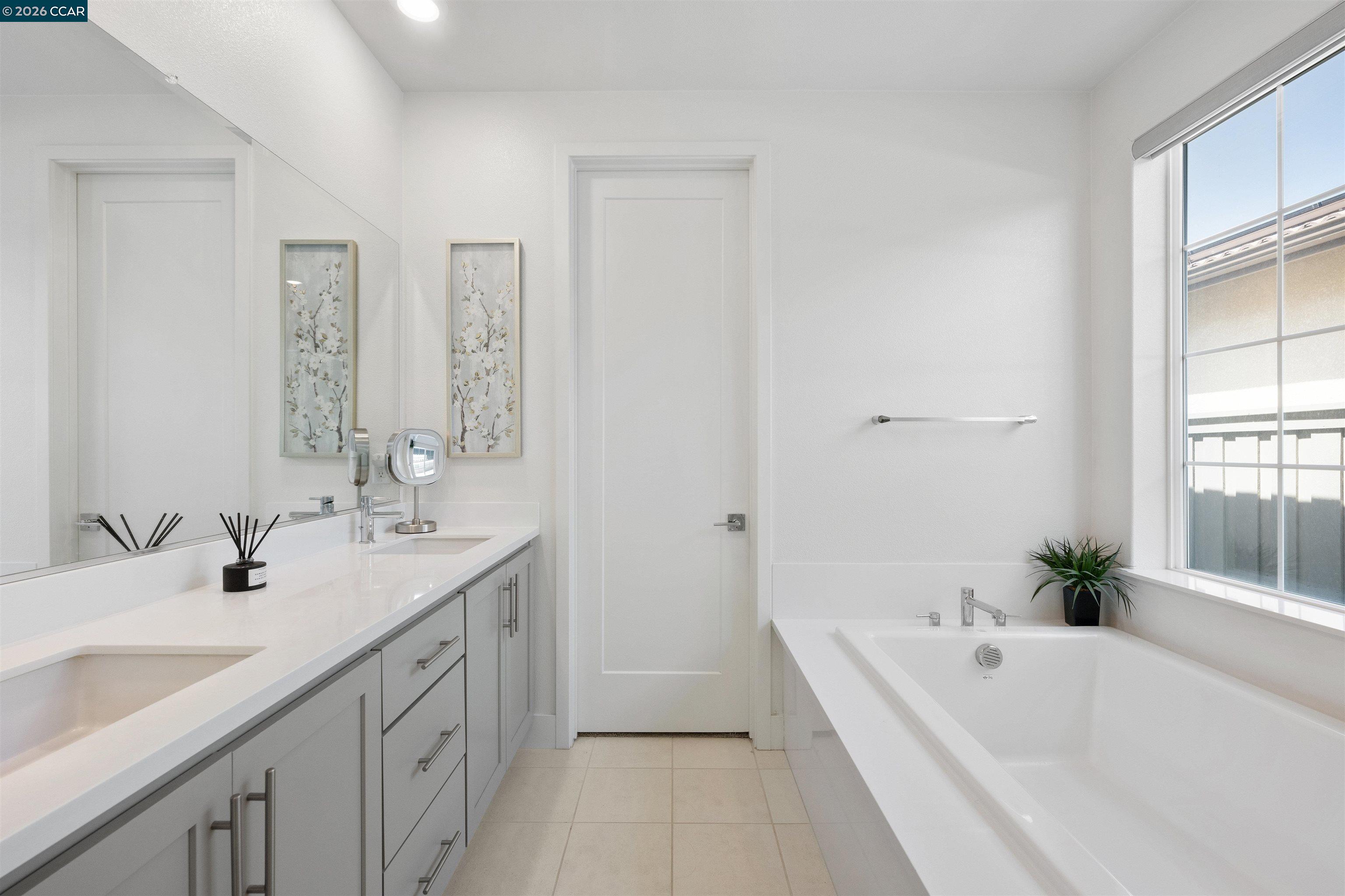 6274 Carousel Avenue Tracy, CA 95377 - Photo 29 of 46 a bathroom with a double vanity sink a mirror and a bathtub