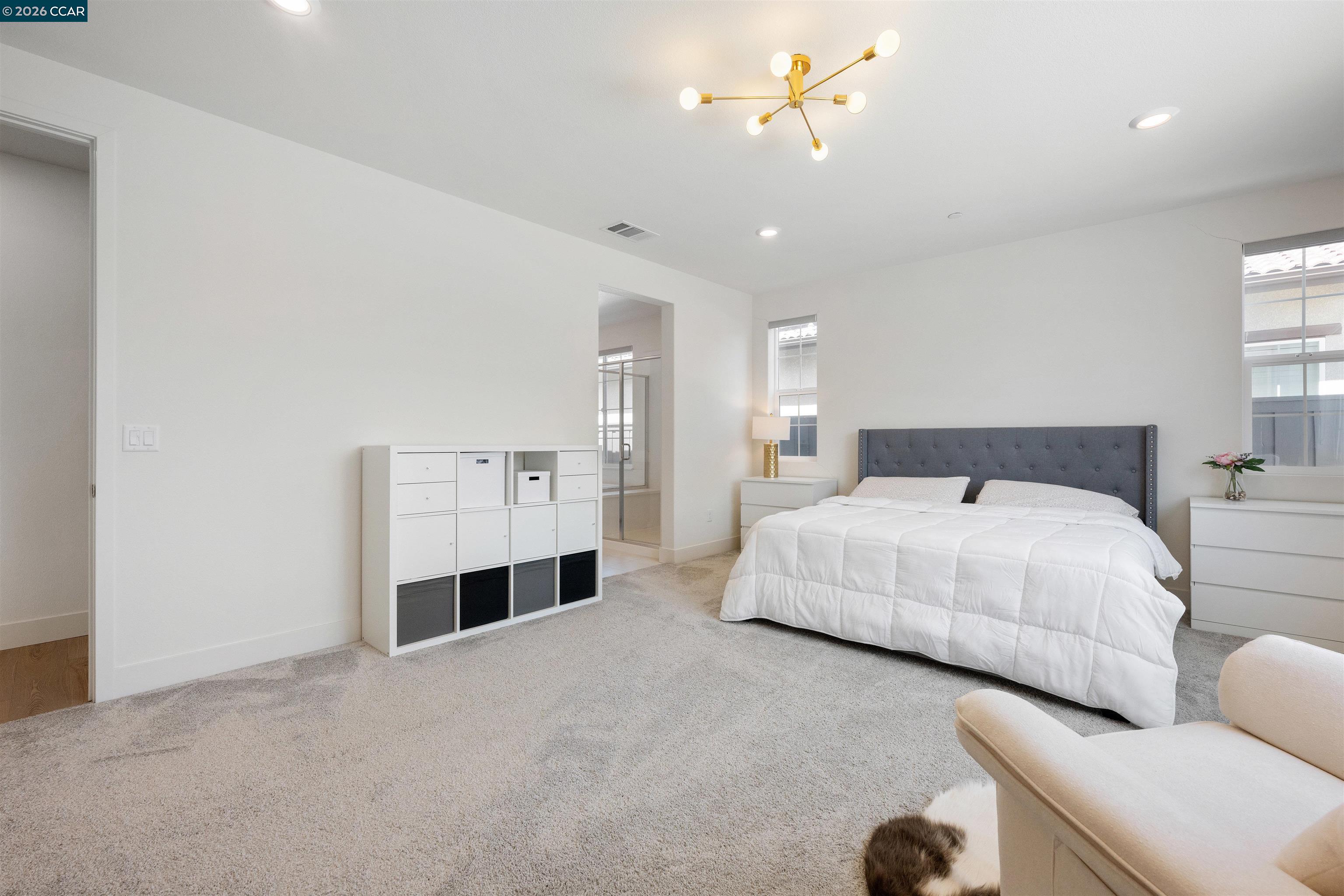 6274 Carousel Avenue Tracy, CA 95377 - Photo 38 of 46 a spacious bedroom with a bed and a chandelier