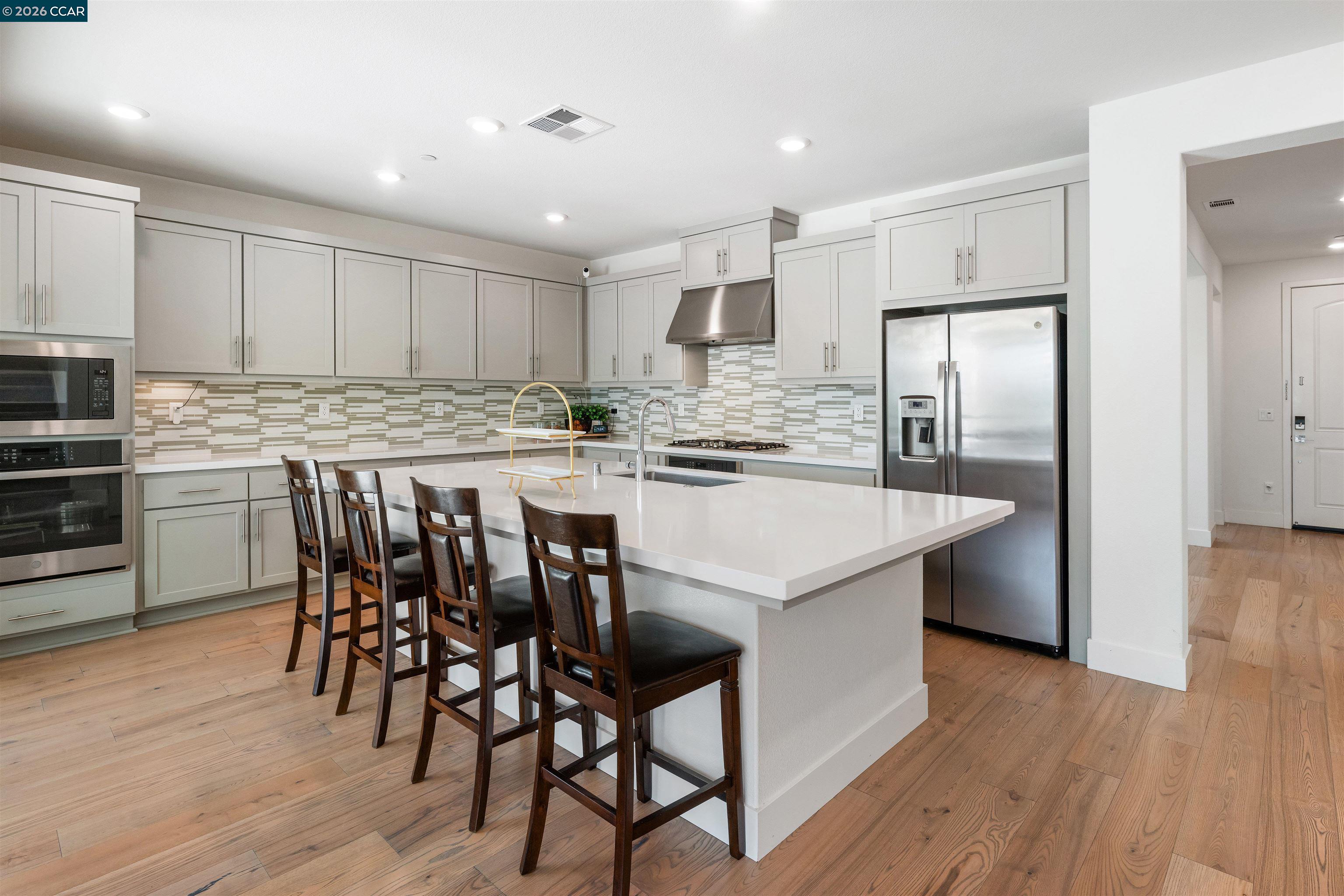 6274 Carousel Avenue Tracy, CA 95377 - Photo 9 of 46 a kitchen with stainless steel appliances granite countertop a dining table chairs refrigerator and cabinets