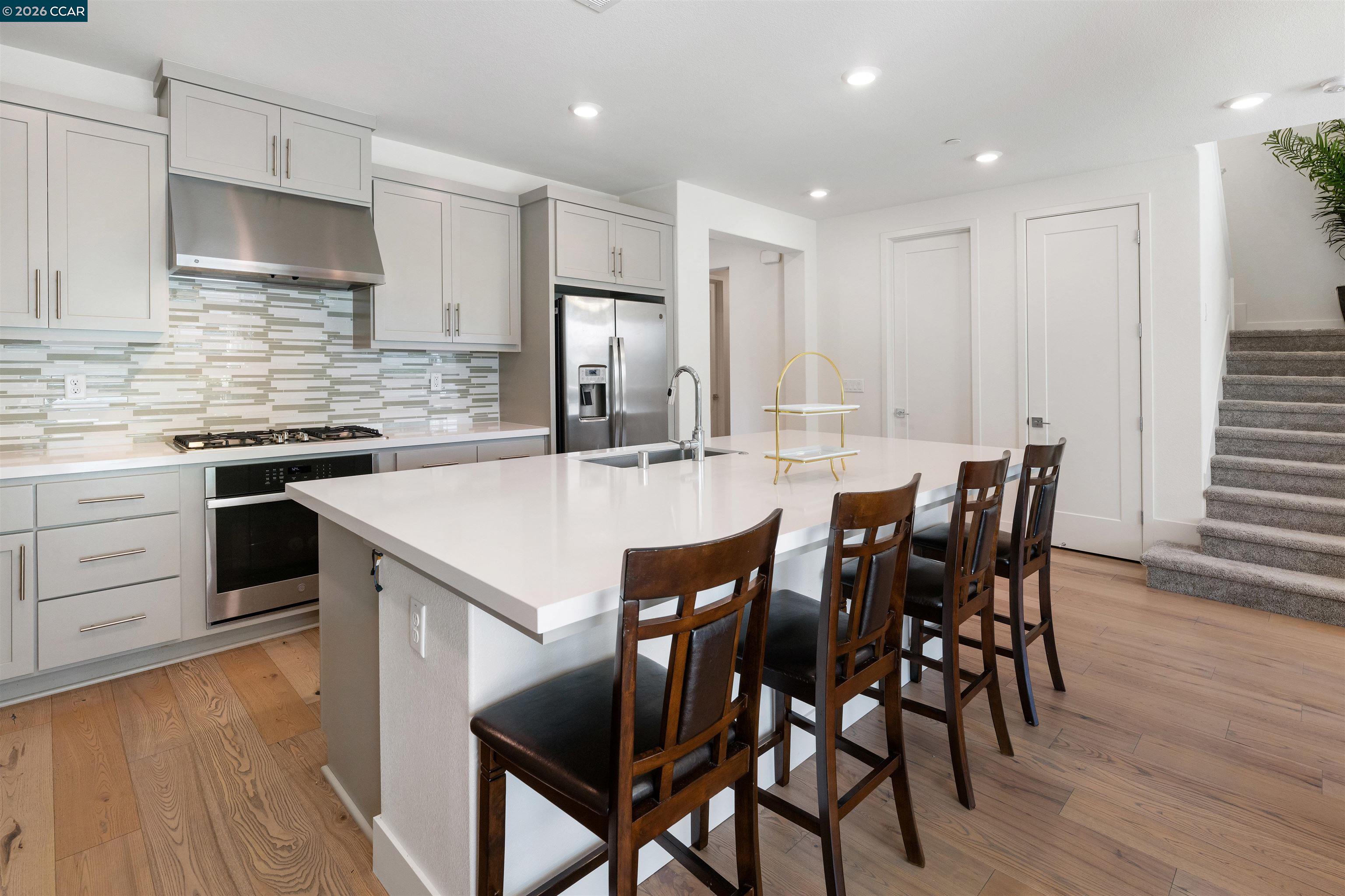 6274 Carousel Avenue Tracy, CA 95377 - Photo 10 of 46 a kitchen with stainless steel appliances kitchen island granite countertop a dining table chairs and sink