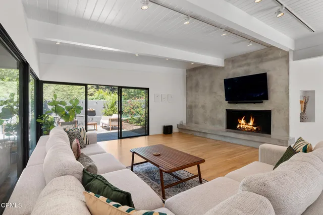 a living room with furniture a flat screen tv and a fireplace