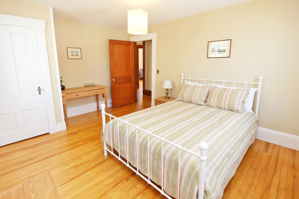 346 Merrimac Street Newburyport, MA 01950 - Photo 17 of 30 a bedroom with a bed and wooden floor