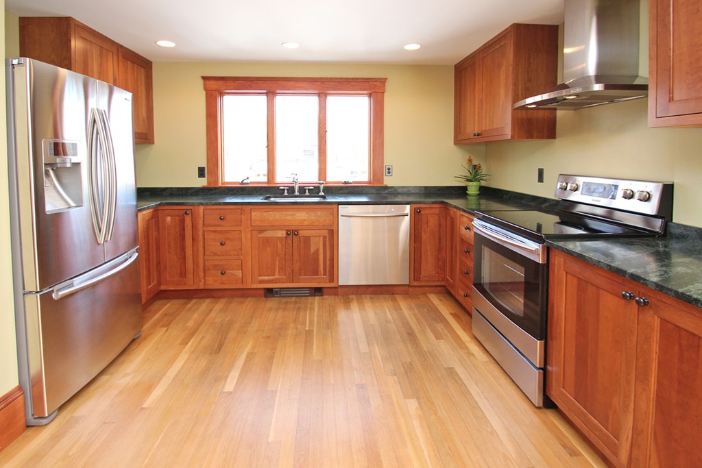 346 Merrimac Street Newburyport, MA 01950 - Photo 7 of 30 a kitchen with stainless steel appliances granite countertop a refrigerator a sink dishwasher a stove and white countertops with wooden floor
