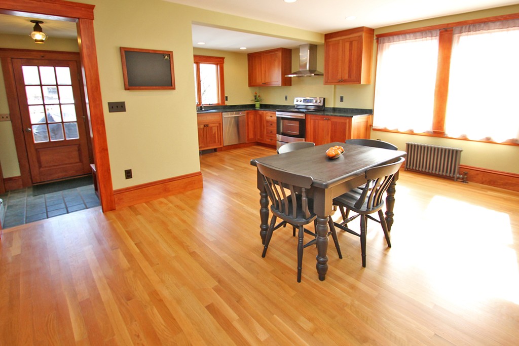 346 Merrimac Street Newburyport, MA 01950 - Photo 9 of 30 a kitchen with stainless steel appliances granite countertop a stove top oven a sink a dining table and chairs with wooden floor