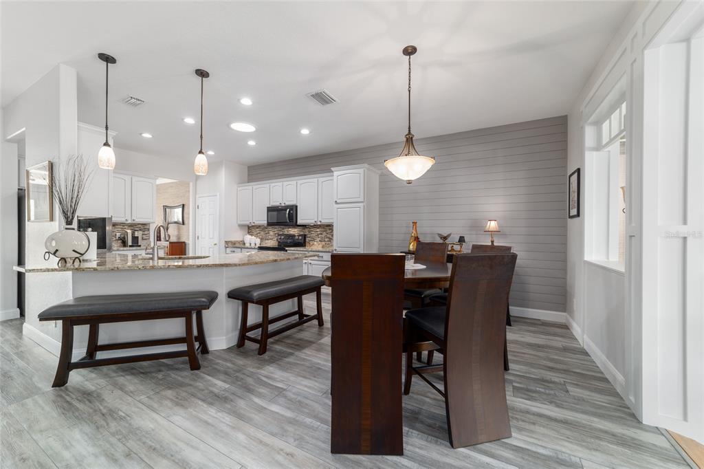 11888 Southeast 91st Circle Summerfield, FL 34491 - Photo 23 of 67 a view of a dining room and livingroom with furniture wooden floor a chandelier