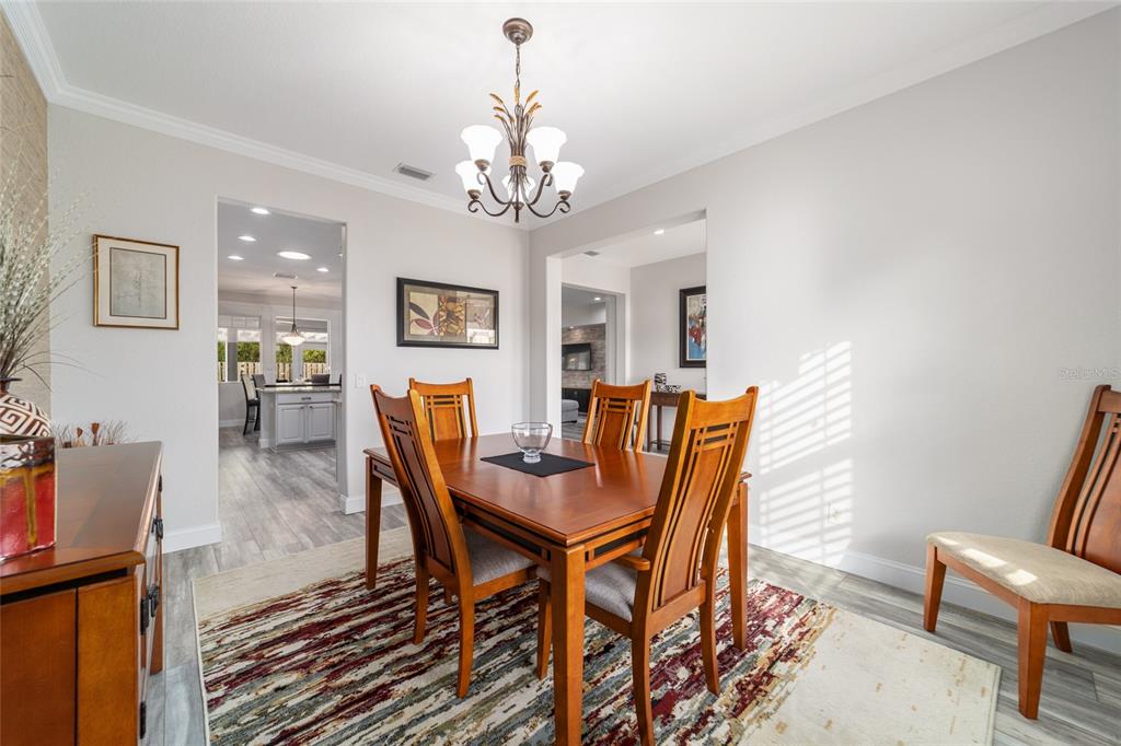 11888 Southeast 91st Circle Summerfield, FL 34491 - Photo 34 of 67 a view of a dining room with furniture a chandelier and wooden floor