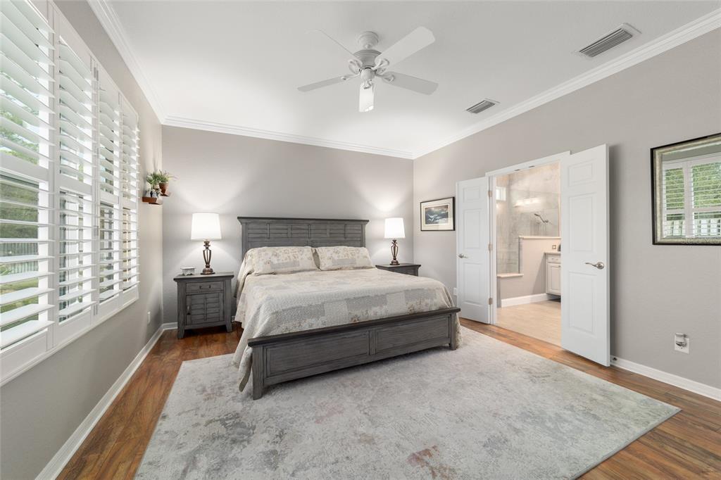 11888 Southeast 91st Circle Summerfield, FL 34491 - Photo 37 of 67 a bedroom with a large bed and a chandelier fan