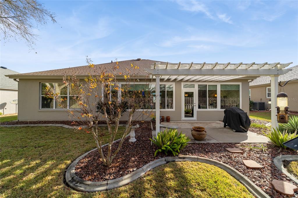 11888 Southeast 91st Circle Summerfield, FL 34491 - Photo 64 of 67 a view of a house with backyard swimming pool and sitting area