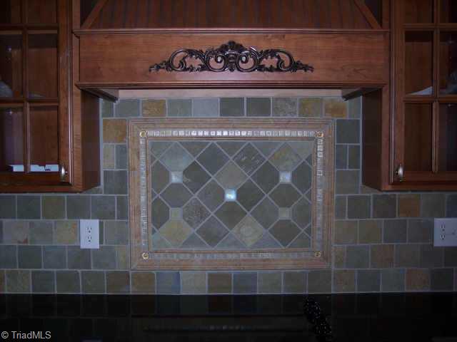 6 Baltimore Downs Road Advance, NC 27006 - Photo 4 of 9 Other. Slate with Glass Medallions Accent Wall Between Decorative Exhaust Fan and Smooth Top Range
