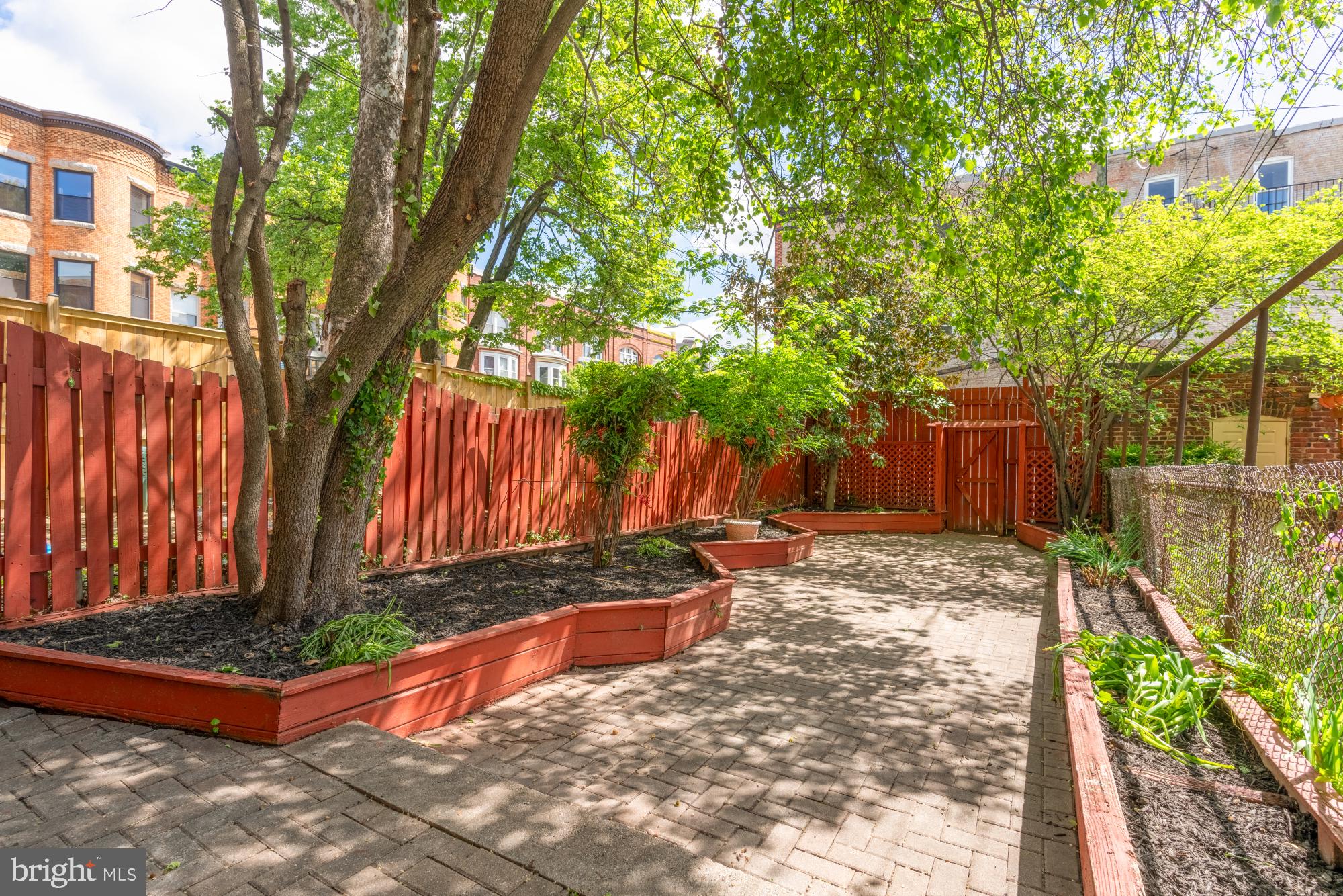 2133 Bolton Street Baltimore, MD 21217 - Photo 44 of 53 a view of a backyard with large trees and wooden fence