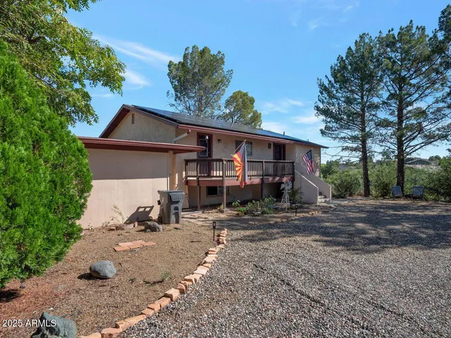 a view of a house with backyard and trees