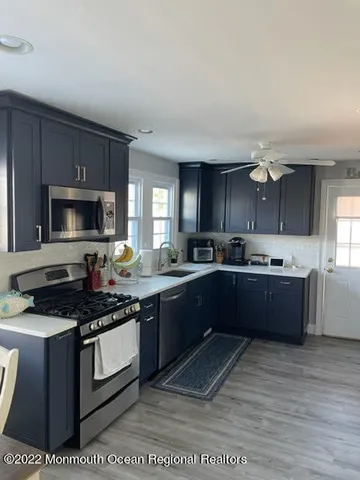 a kitchen with stainless steel appliances granite countertop a stove a sink dishwasher and a microwave oven with cabinets