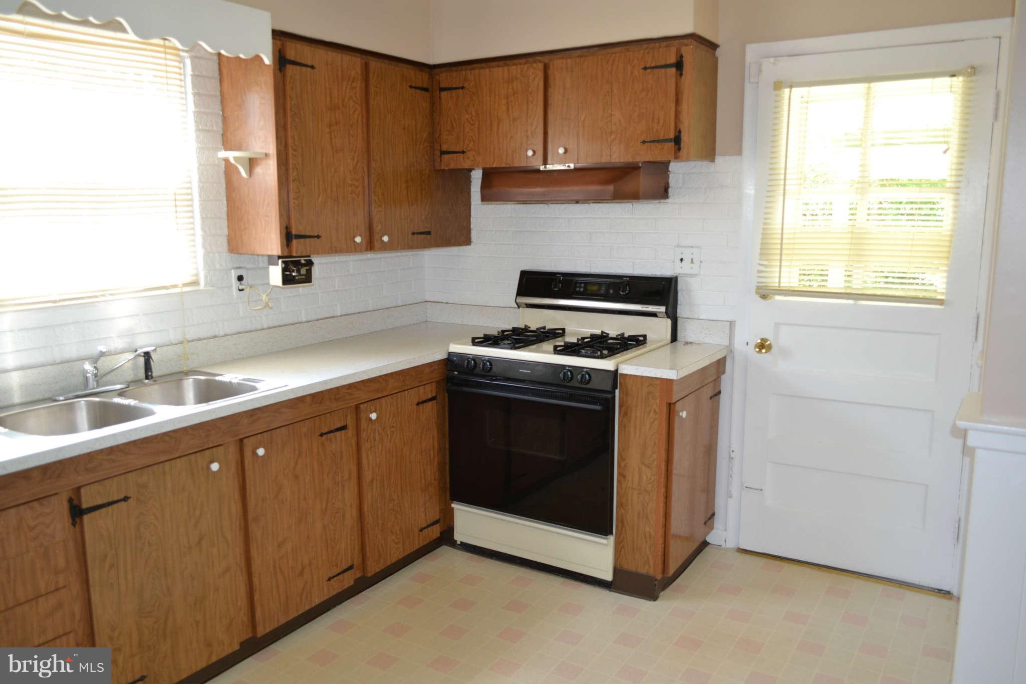1406 Woodbridge Road Baltimore, MD 21228 - Photo 2 of 18 a kitchen with cabinets appliances a sink and a window