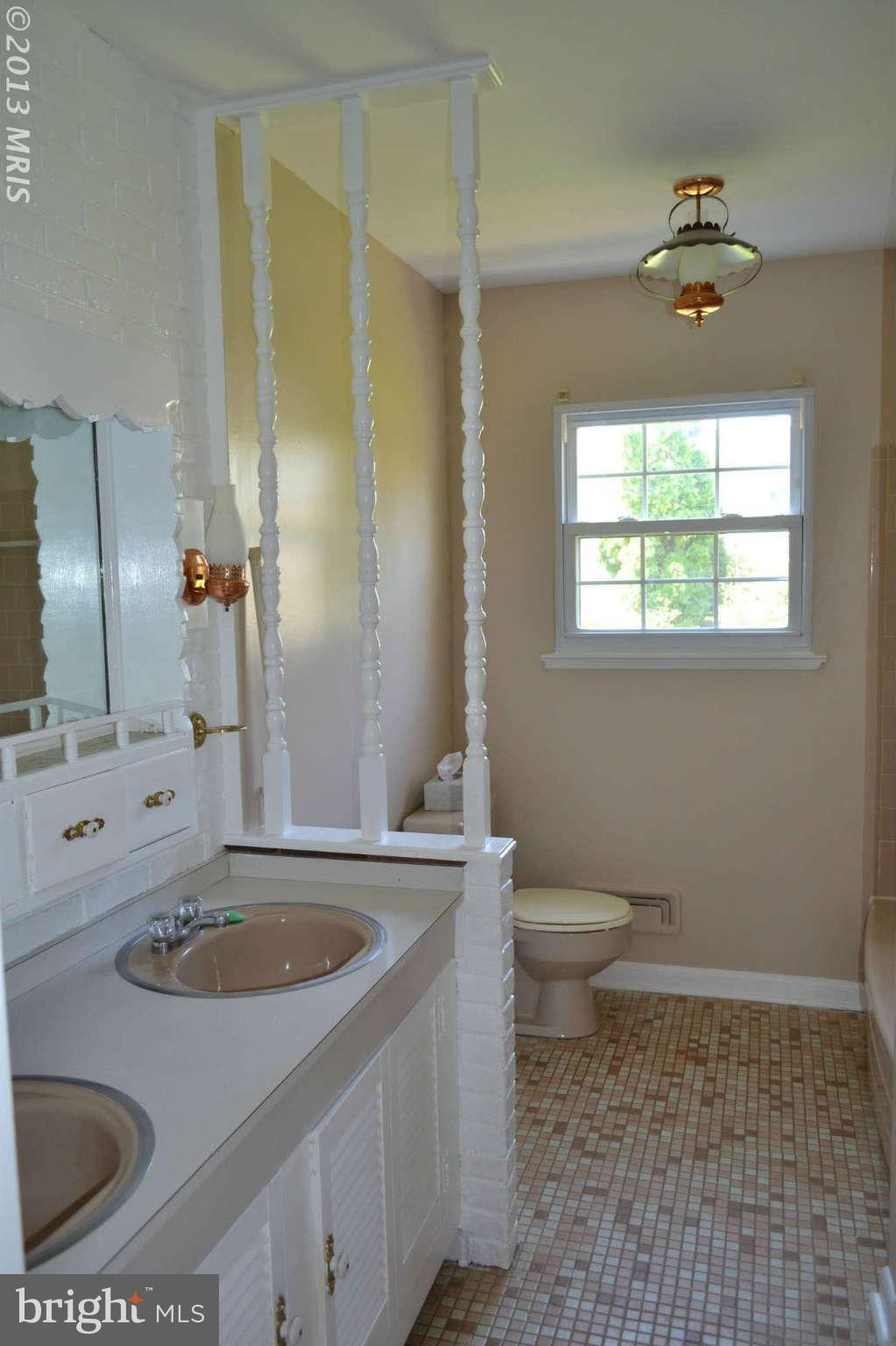 1406 Woodbridge Road Baltimore, MD 21228 - Photo 11 of 18 a bathroom with a sink a toilet and a mirror