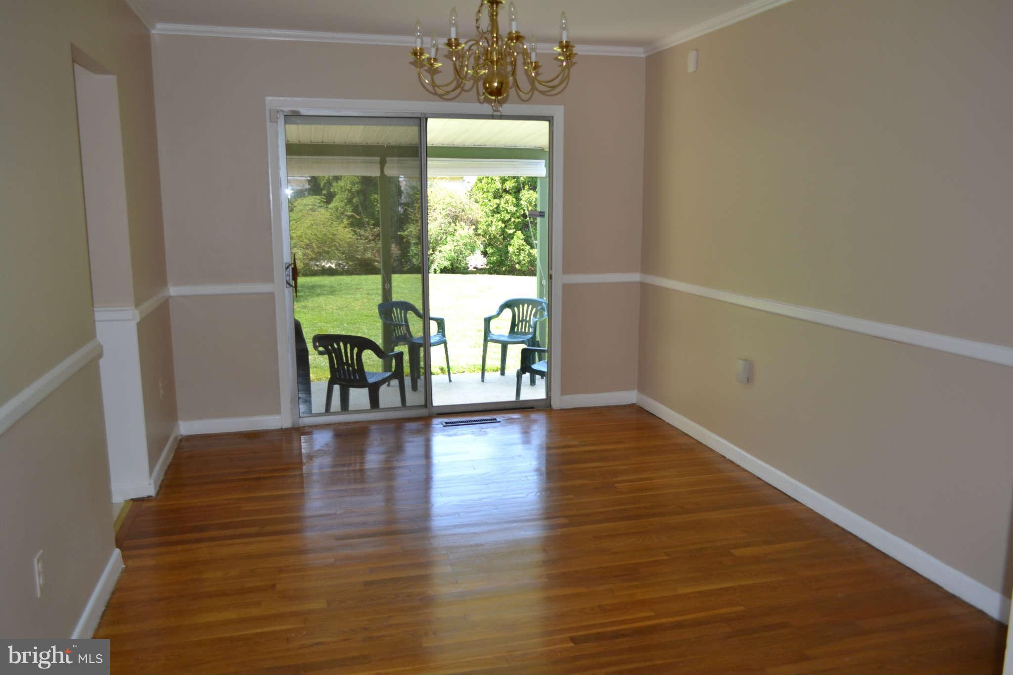 1406 Woodbridge Road Baltimore, MD 21228 - Photo 4 of 18 a view of empty room with wooden floor and fan