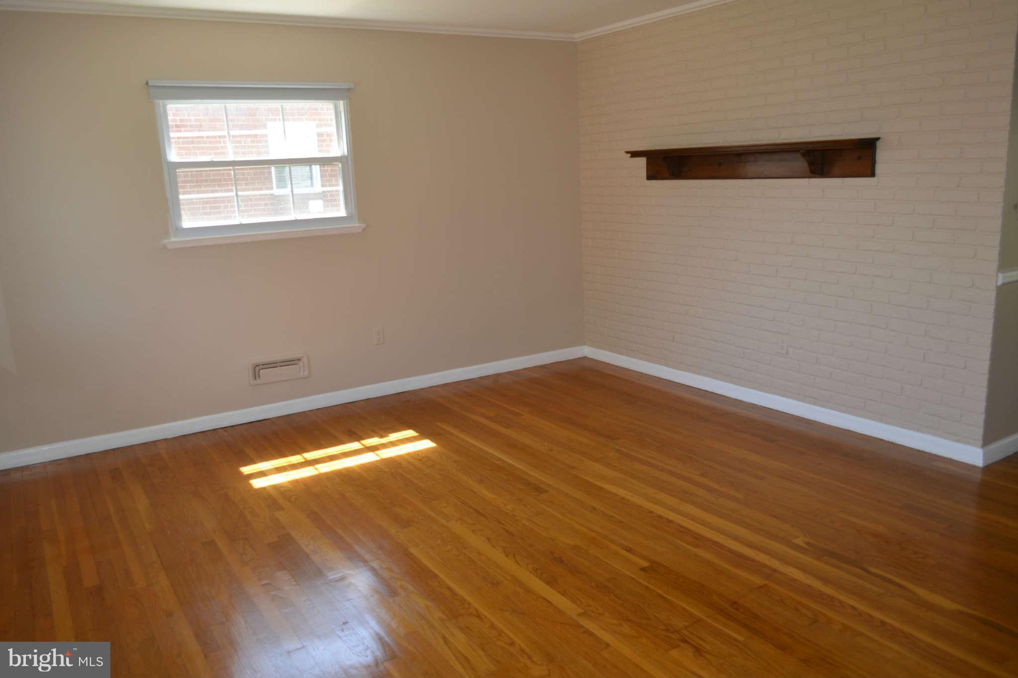 1406 Woodbridge Road Baltimore, MD 21228 - Photo 5 of 18 a view of empty room with wooden floor and fan