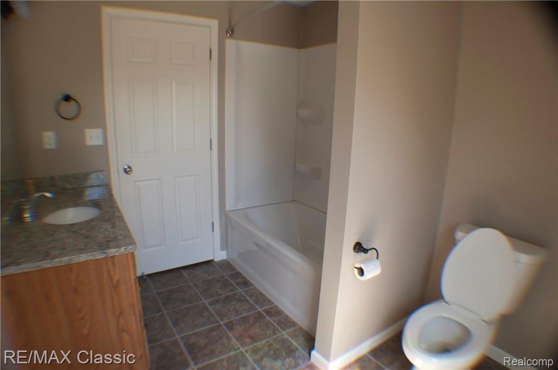 2038 Covert Road Burton, MI 48509 - Photo 11 of 25 UPSTAIRS BATH WITH GRANITE, OAK AND CERAMIC