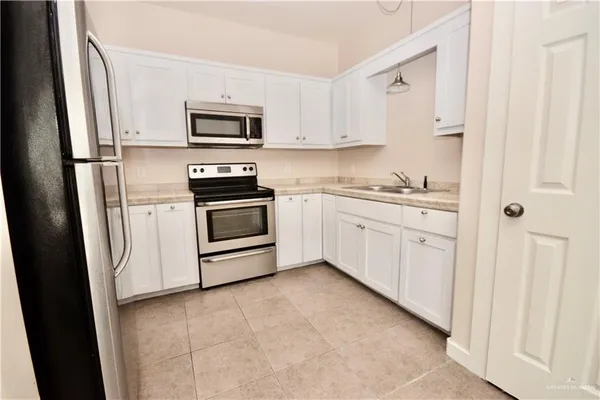 a kitchen with stainless steel appliances granite countertop a refrigerator and a stove top oven
