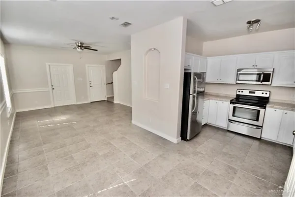 a view of a kitchen with refrigerator and a stove top oven