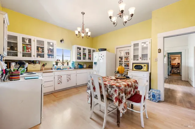 a kitchen with stainless steel appliances kitchen island granite countertop a table and chairs in it