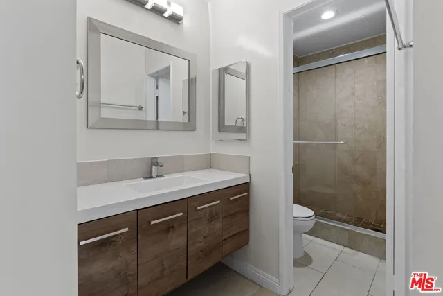 a bathroom with a granite countertop sink mirror and a shower