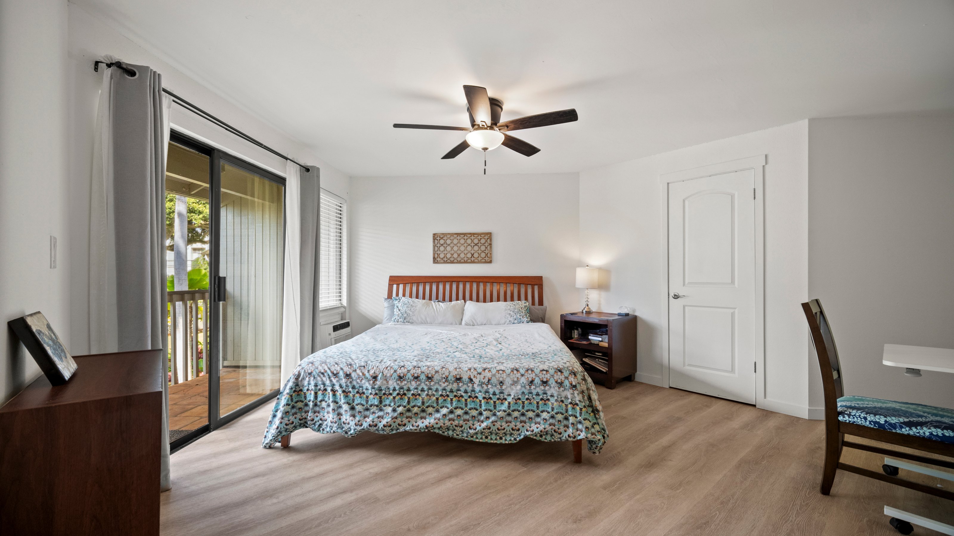 4121 Rice Street, Unit 2708 Lihue, HI 96766 - Photo 13 of 29 a bedroom with a bed a dresser and wooden floor