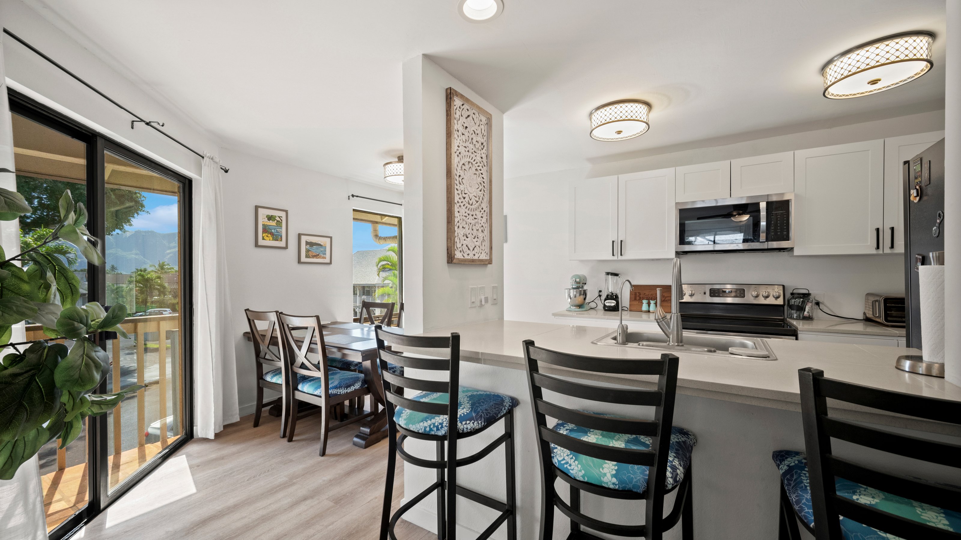 4121 Rice Street, Unit 2708 Lihue, HI 96766 - Photo 2 of 29 a kitchen with a table chairs microwave and cabinets
