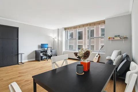 a dining room with furniture and a large window