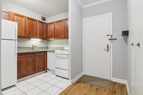 a kitchen with a refrigerator sink and cabinets