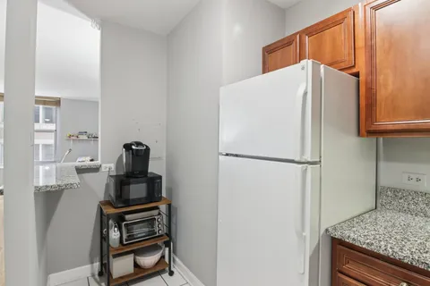 a white refrigerator freezer and a stove sitting inside of a kitchen