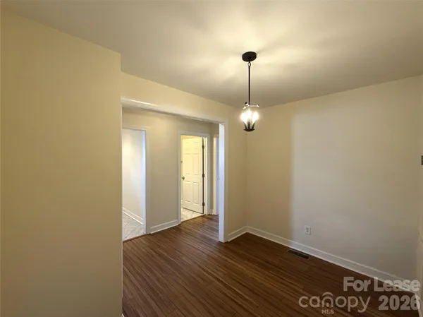 a view of a room with wooden floor and ceiling fan