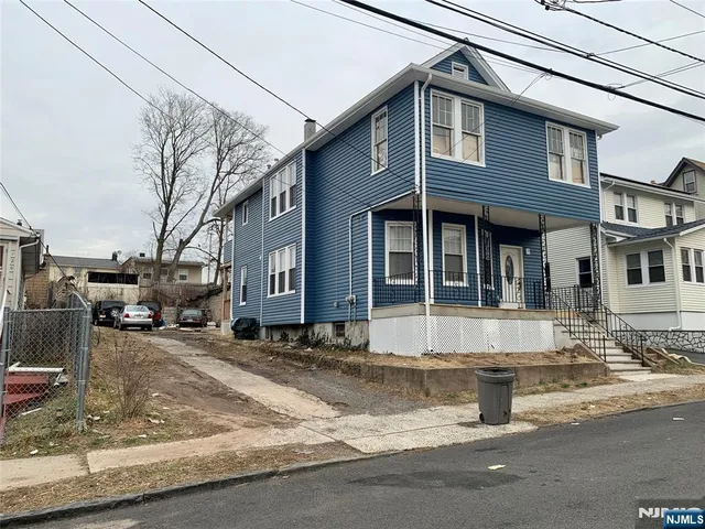 a view of a white house with large windows next to a road