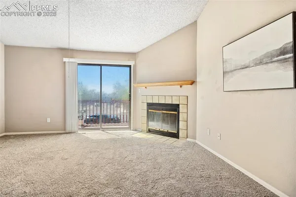 a view of an empty room with a fireplace and a window