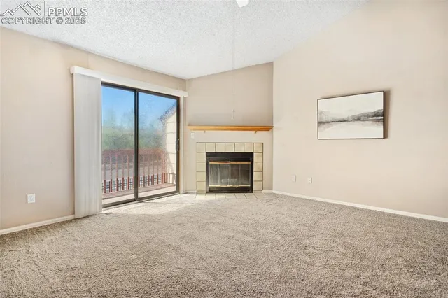 a view of an empty room with a fireplace and a window
