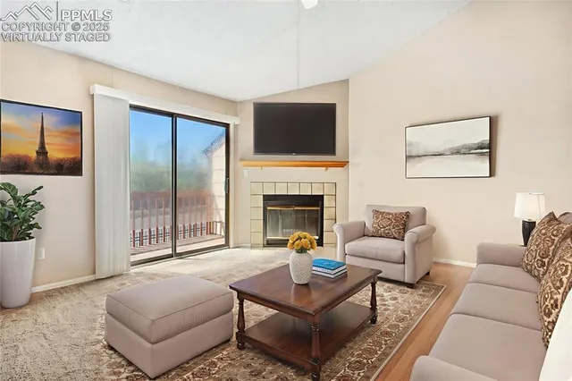 a living room with furniture a flat screen tv and a fireplace