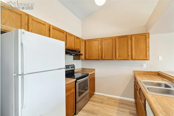 a kitchen with a refrigerator a stove top oven a sink and dishwasher