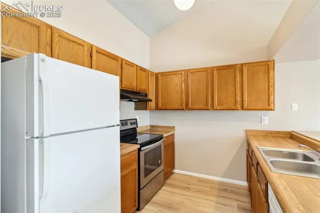 a kitchen with a refrigerator a stove top oven a sink and dishwasher
