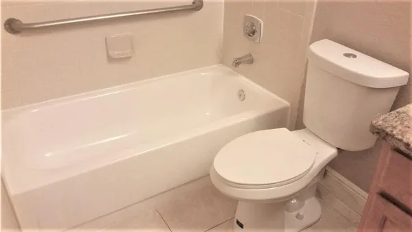 a white toilet sitting next to a bath tub