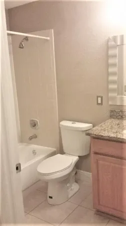 a bathroom with a granite countertop toilet a sink and a bathtub