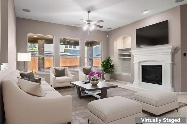 a living room with furniture a flat screen tv and a fireplace